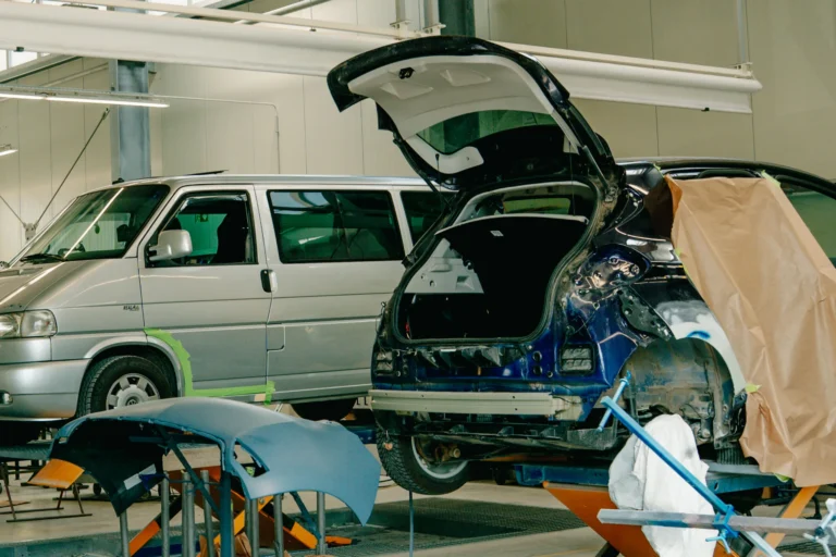 Ein PKW und ein VW Bus stehen auf Hebebühnen in einer Karosseriewerkstatt bei Würzburg